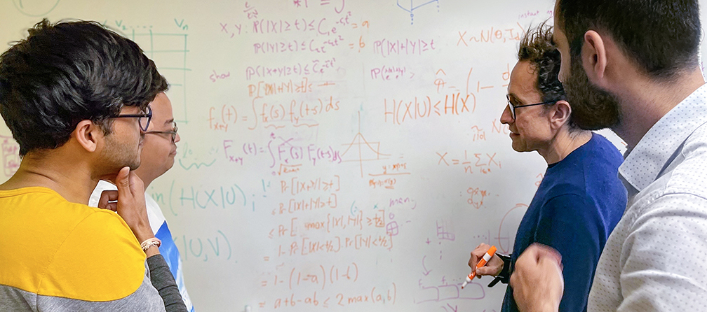 Research team discussing algorithms on whiteboard